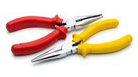Professional needle nose pliers with red and yellow handles isolated on white background for electrical work and precision tasks.