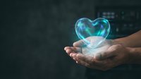 Glowing holographic heart floating above open hands against dark background. Digital healthcare technology concept for medical innovation and wellness.