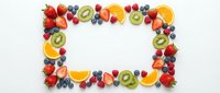 Colorful fresh fruit frame border made of strawberries, blueberries, kiwi, orange slices and berries on white background with copy space for text.