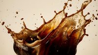 Dynamic cola splash with amber liquid droplets frozen in motion against neutral background for beverage advertising and refreshment concepts.