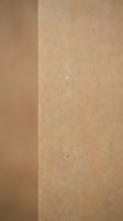 Minimalist beige textured wall corner with natural lighting creating soft shadows and warm neutral tones for modern interior design backgrounds.