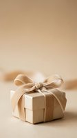 Kraft paper wrapped gift box with beige ribbon bow on neutral background, suitable for holiday, birthday, and celebration packaging design projects.