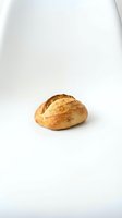 Fresh artisan bread roll with golden crust isolated on white background for bakery and food design projects.