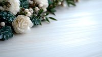 Elegant white roses and eucalyptus leaves arrangement on light wooden background with copy space. Wedding floral composition for invitation design.