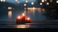 Glowing red candles on wooden surface against blurred bokeh lights background create atmospheric evening mood for meditation, romance, or spiritual moments.