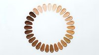 Diverse foundation makeup shades arranged in perfect circle showing wide range of skin tones from light to deep for inclusive beauty and cosmetics.
