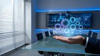 Businessman hand presenting glowing gears and digital network interface in modern conference room with blue lighting, symbolizing technology innovation and business solutions.
