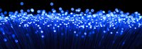Glowing blue fiber optic strands illuminate against dark background creating magical light effect pattern, modern technology and communication concept.