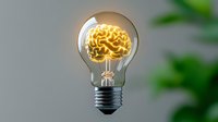 Glowing brain-shaped filament inside light bulb against blurred green background symbolizes creative thinking, innovation and bright ideas.