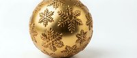 Golden Christmas ornament ball with intricate snowflake patterns on white background, perfect for holiday decorations and festive seasonal designs.