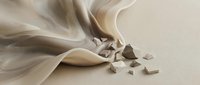 Flowing beige fabric with scattered geometric shapes on neutral background, suitable for abstract design, textile concepts, and modern artistic compositions.