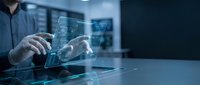 Engineer or technician with light skin tone examining holographic digital interface display with circuit board patterns and data visualization on transparent screen in modern tech environment.