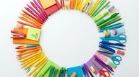Colorful school and office supplies arranged in circular frame on white background. Pens, pencils, scissors, erasers for education projects.