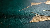 Peeling paint texture showing emerald green and metallic gold layers on rough surface, creating abstract pattern with cracked and worn appearance. Artistic macro photography.