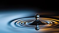 Single water drop creating concentric ripples on liquid surface with dramatic blue and orange lighting, captured at high speed with reflection and symmetry.