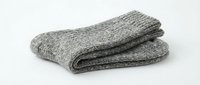 Pair of folded gray wool knit socks on white background, isolated, cozy winter accessory for cold weather comfort and warmth.