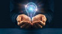 Businessman hands holding glowing light bulb with brain inside representing innovation, creativity, artificial intelligence and bright ideas for business solutions.