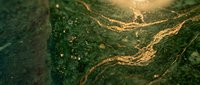 Luxurious green marble texture with golden veins and sparkles creating elegant natural stone surface for premium interior design and decoration projects.