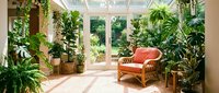 Bright sunroom conservatory with lush tropical plants, wicker furniture and natural light streaming through glass walls creating peaceful indoor garden retreat.