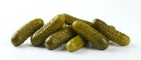 Pile of fresh green pickled cucumbers isolated on white background, ready for food and culinary design projects.