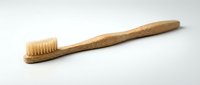 Natural bamboo toothbrush with soft bristles isolated on white background for eco-friendly dental care and sustainable oral hygiene routine.