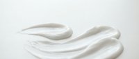 White cosmetic cream texture with smooth swirls and peaks on clean background for skincare and beauty product applications.