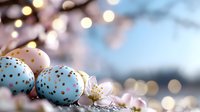 Pastel blue Easter eggs decorated with gold dots alongside delicate spring blossoms against soft bokeh background, creating festive holiday atmosphere.