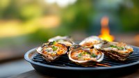 Grilled oysters with melted butter and herbs sizzling on hot barbecue grate, flames in background creating atmospheric outdoor dining scene. Fresh seafood cooking.