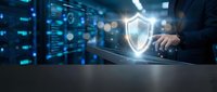 Cybersecurity professional protecting digital data with shield icon in modern server room environment for business technology solutions.