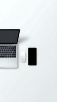 Modern workspace with laptop computer, smartphone and wireless mouse on clean white desk surface for business and technology projects.