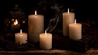Atmospheric arrangement of burning candles with rising smoke on rustic wooden surface, creating cozy ambiance for meditation, relaxation or spiritual practices.