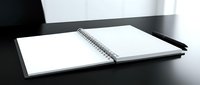 Open blank notebook with spiral binding and black pen on dark wooden desk surface for business planning and creative writing projects.