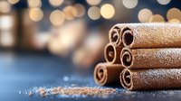 Aromatic cinnamon sticks dusted with sugar powder on dark background with golden bokeh lights, macro food photography for winter holiday season.