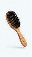 Wooden hairbrush with natural boar bristles on white background, used for styling, grooming, and hair care treatments.