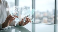 Businessman hands holding holographic world map with digital network connections in modern office environment for global business technology concepts.