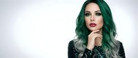 Young woman with vibrant green ombre hair and bold makeup posing against white background for beauty and fashion concepts.