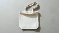 Blank white cotton tote bag with natural handles isolated on light background, ready for custom printing, branding, and merchandise design projects.