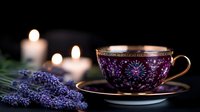 Elegant teacup with purple floral pattern and gold trim alongside fresh lavender sprigs and glowing candles creating serene atmosphere for relaxation and mindfulness.