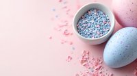 Easter composition with blue painted egg and bowl of pastel sugar sprinkles on pink background. Festive spring holiday baking decoration concept.