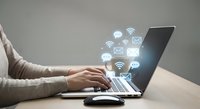 Digital communication icons floating from laptop screen as person types, representing modern connectivity and online networking technology.