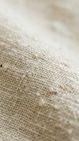 Natural linen fabric texture close-up with woven fibers and organic cotton material surface for textile design and crafting projects.