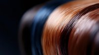 Abstract blurred motion background with smooth gradient transition between dark blue and copper brown colors creating dynamic flowing curves and waves.
