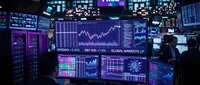 Modern financial trading floor with multiple screens displaying stock market data, charts and analytics for investment and business analysis.