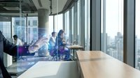 Modern business team collaborating in glass conference room with city skyline view, discussing digital strategy and innovation in corporate office environment.