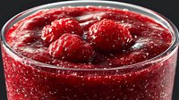 Fresh raspberry jam with whole berries in glass jar, homemade preserve spread for breakfast toast, desserts and baking recipes.