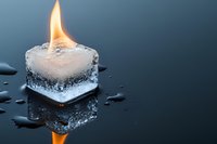 Burning ice cube with flame on water surface creating reflection. Conceptual contrast of fire and ice elements for creative projects and designs.