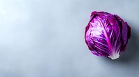 Fresh purple cabbage head on light gray background with copy space, vibrant organic vegetable showing natural texture and layers for healthy eating concept.