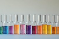 Laboratory glass bottles filled with vibrant colorful liquids in rainbow sequence on light background, scientific research concept for chemistry experiments.
