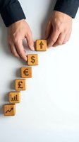 Businessman hands arranging wooden blocks with financial symbols showing growth strategy and currency exchange for investment planning.