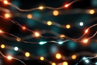 Glowing string lights creating magical bokeh effect against dark background, warm orange and cool teal lights intertwined in festive holiday atmosphere.